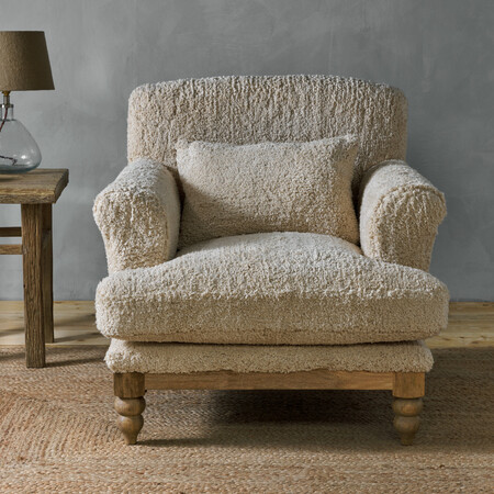 Oversized comfy reading chair or boucle armchair with a soft, fluffy teddy bear style upholstery in off white and a wooden base